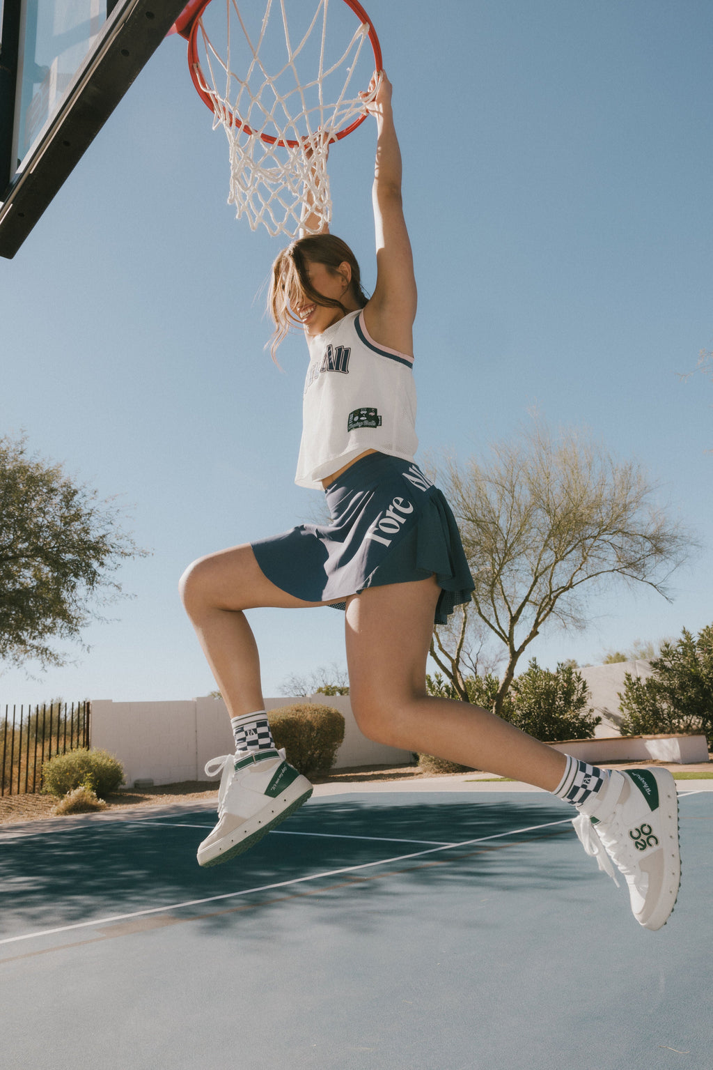 A person wearing a blue skirt with a mesh back. The image focuses on the skirt which has a sports-inspired design.
