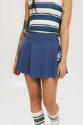 A person wearing a blue skirt with a mesh back, along with a striped top and white socks with green stripes. The image focuses on the skirt which has a sports-inspired design.